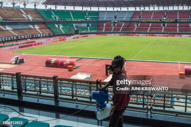 An official sprays disinfectant at a football stadium in Surabaya, East Java, on March 13 to fight against any spread of the COVID-19 coronavirus...