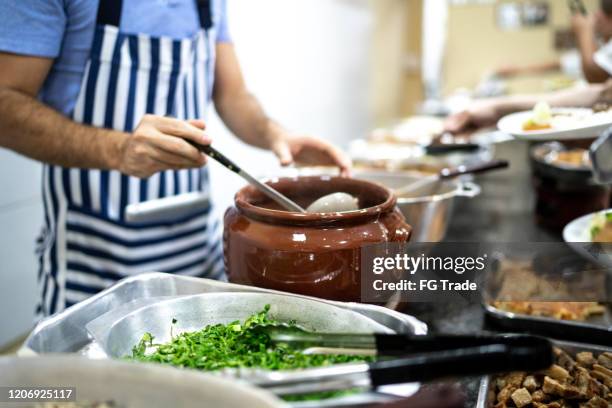 küchenchef serviert essen für die menschen im restaurant - brazilian feijoada dish stock-fotos und bilder