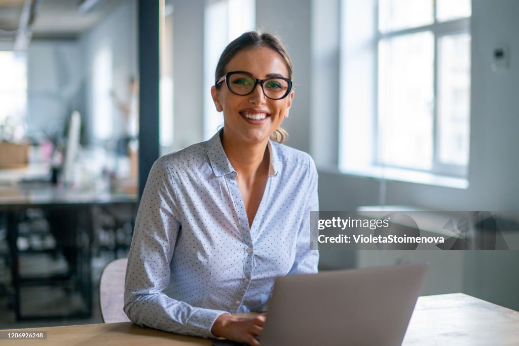 Onderneemster die aan computer in het bureau werkt.