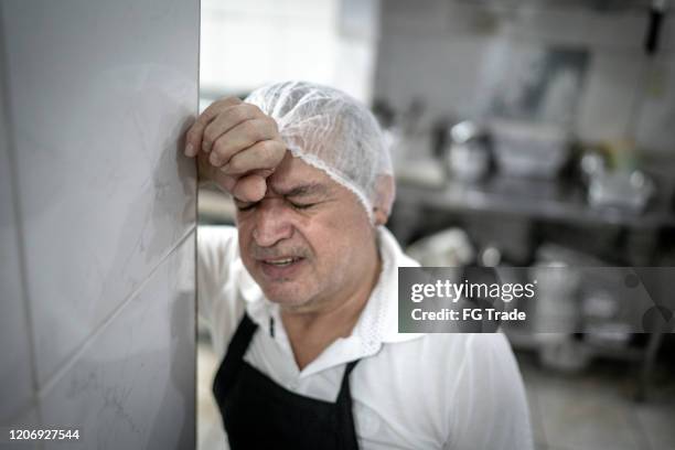 worried chef at industrial kitchen in restaurant - food industry stock pictures, royalty-free photos & images