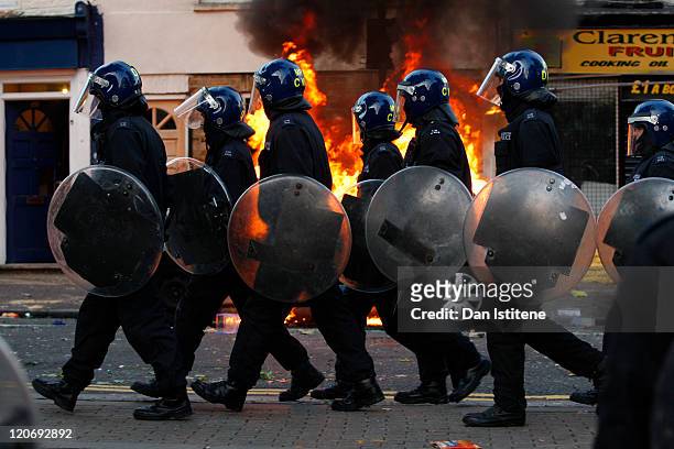 Riot police walk along Clarence Road in Hackney on August 8, 2011 in London, England. Pockets of rioting and looting continues to take place in...
