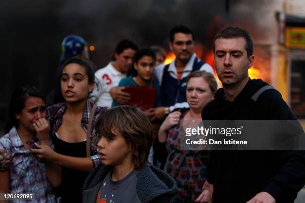 Local residents flee Clarence Road in Hackney on August 8, 2011 in London, England. Pockets of rioting and looting continues to take place in various...