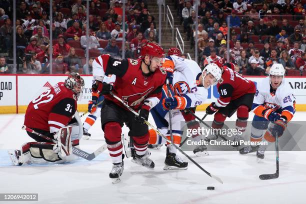Niklas Hjalmarsson of the Arizona Coyotes controls the puck under pressure from Anders Lee of the New York Islanders during the second period of the...