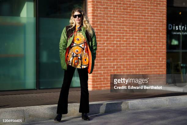 Veronika Heilbrunner wears sunglasses, a green quilted coat with oranger inner lining, a khaki and orange mini dress with printed patterns, black...