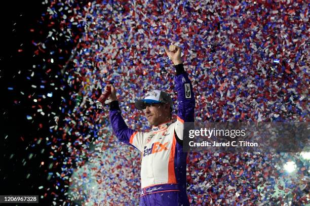 Denny Hamlin, driver of the FedEx Express Toyota, celebrates in Victory Lane after winning the NASCAR Cup Series 62nd Annual Daytona 500 at Daytona...