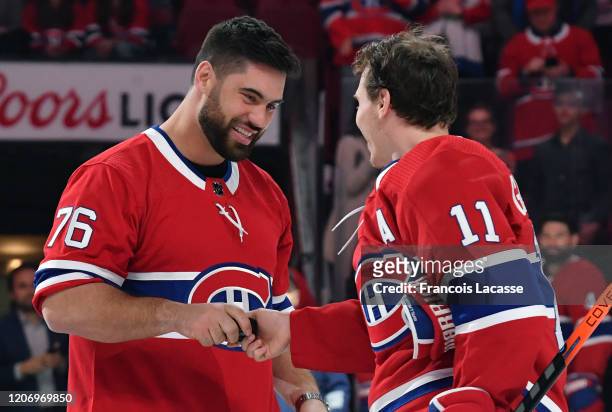 Brendan Gallagher of the Montreal Canadiens greets Canadian football player Laurent Duvernay-Tardif in a ceremony prior to the NHL game between the...