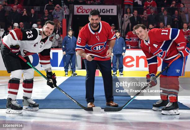 Canadian football player Laurent Duvernay-Tardif gets set to drop the ceremonial puck along with Brendan Gallagher of the Montreal Canadiens and...