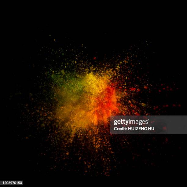 explosion of colored powder on black background - orange powder stock pictures, royalty-free photos & images