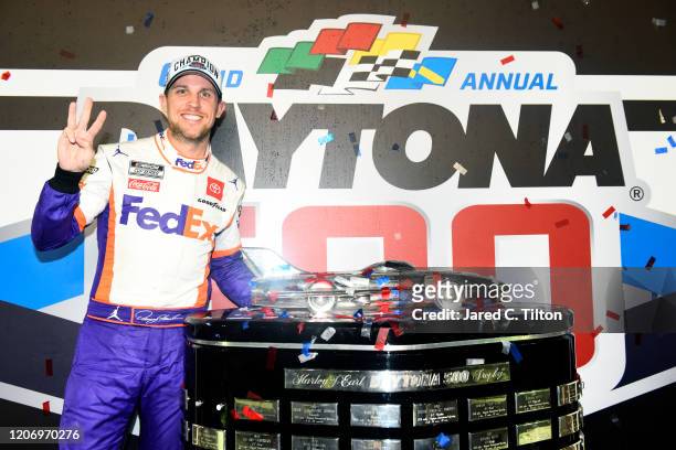 Denny Hamlin, driver of the FedEx Express Toyota, poses with the trophy in Victory Lane after winning the NASCAR Cup Series 62nd Annual Daytona 500...