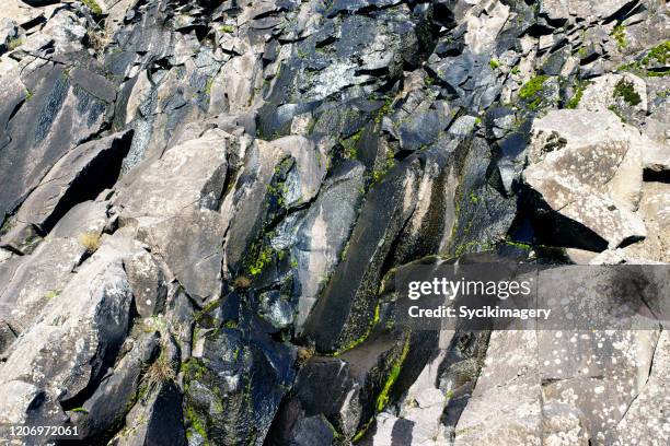 water flowing down rocky cliff side - rock face stock pictures, royalty-free photos & images