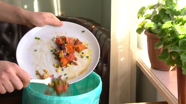 Housewife throws baked vegetables in the trash