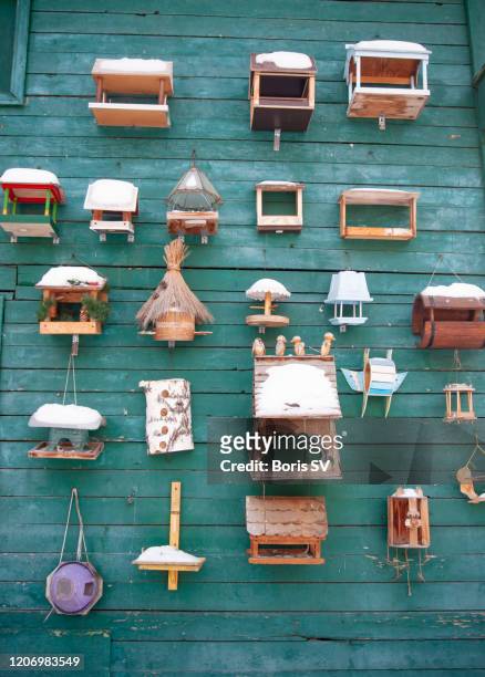 snowcapped bird houses on the green wall - aviary stock pictures, royalty-free photos & images