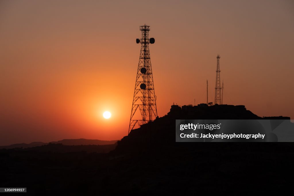 Silhouette of communication tower for broadcasting during sunrise time.