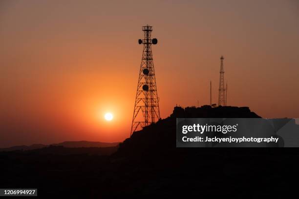 silhouette of communication tower for broadcasting during sunrise time. - torre di trasmissione a microonde foto e immagini stock