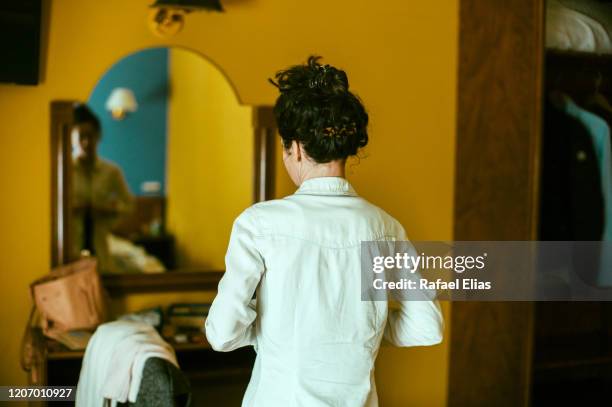 woman in front of mirror changing her blouse - schizophren stock-fotos und bilder