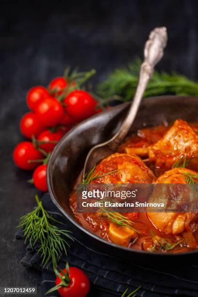stewed chicken legs with tomato sauce on dark background - chicken stew stock pictures, royalty-free photos & images