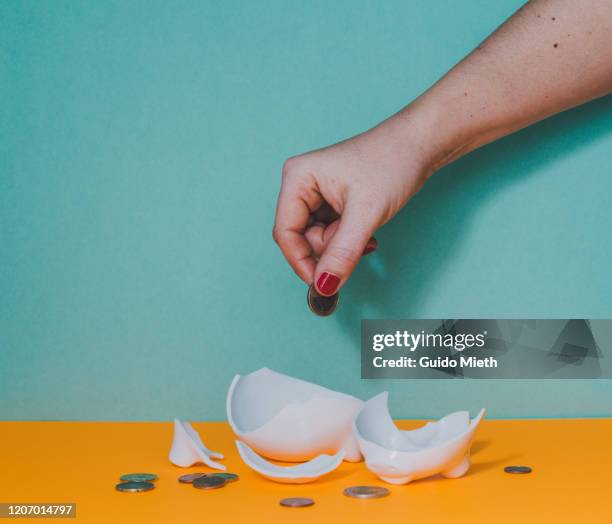 hand counting coins from broken piggy bank. - smashed piggy bank stock pictures, royalty-free photos & images