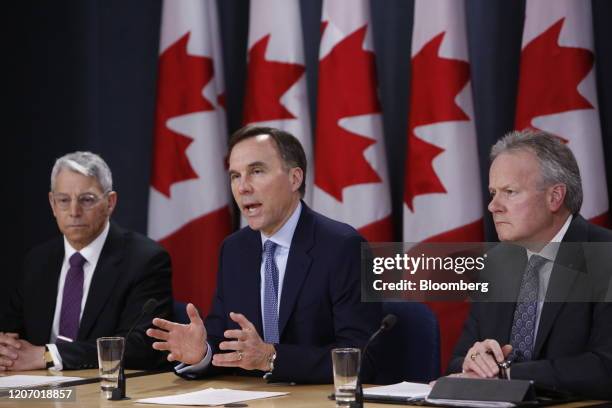 Bill Morneau, Canada's minister of finance, center, speaks while Stephen Poloz, governor of the Bank of Canada, right, and Jeremy Rudin, head of the...