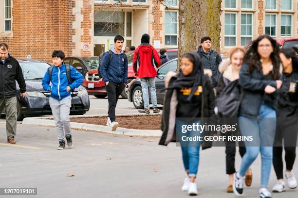 Secondary school students leave Central Collegiate Institute in London, Ontario on March 13, 2020 on their last day of classes before a 3 week break...