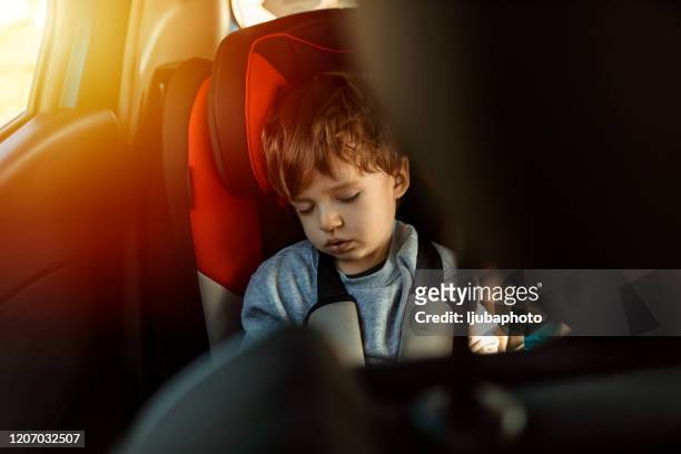 jongen die op achterbank van auto slaapt - sleeping in car stockfoto's en -beelden