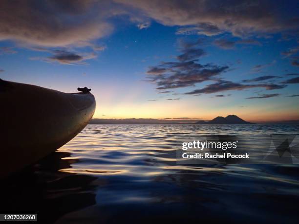 canoe on ocean & volcano at sunset - rabaul stock pictures, royalty-free photos & images