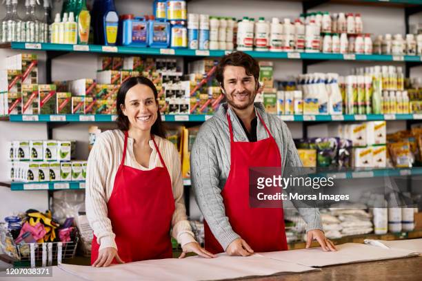 portrait of smiling owners standing at counter - mid adult men stock pictures, royalty-free photos & images