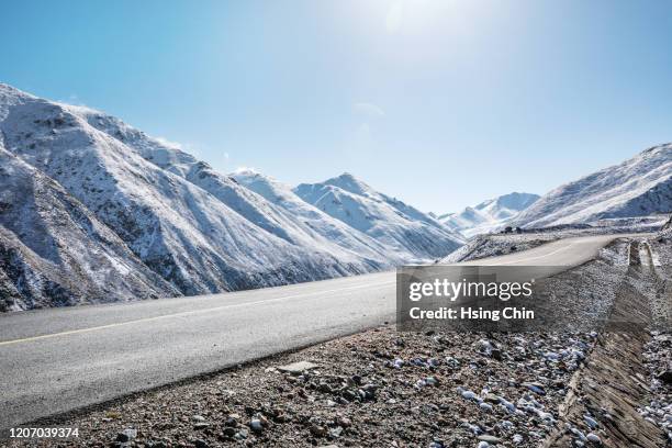 snow mountain road - snow covered road stockfoto's en -beelden
