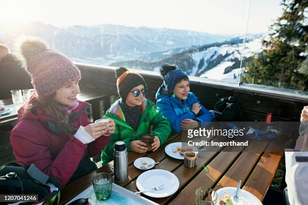 petits skieurs mangeant le déjeuner dans le bar de ski alpin - sport d'hiver photos et images de collection
