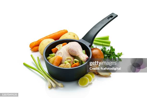 ingredientes de caldo de pollo en una sartén aislada sobre fondo blanco - caldo fotografías e imágenes de stock