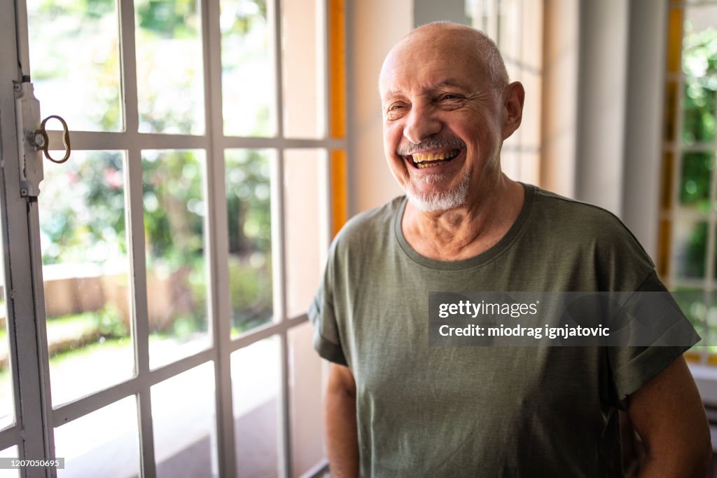 Portrait of happy senior man at home