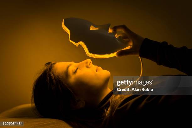 led mask regenerative treatment applied to a young woman - luce led foto e immagini stock