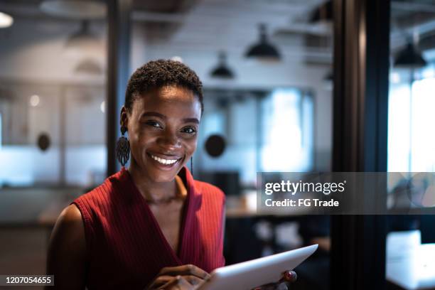 portret van onderneemster die digitale tablet bij bureau gebruikt - global best pictures stockfoto's en -beelden