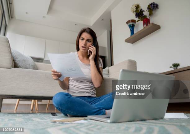kvinna hemma klagar på en räkning på telefon - klaga bildbanksfoton och bilder