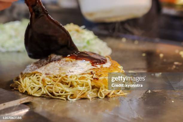 estilo de hiroshima okonomiyaki - bañar en su jugo durante la cocción fotografías e imágenes de stock