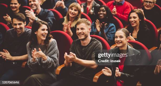 fröhliches publikum applaudiert im theater - publikum lachen stock-fotos und bilder