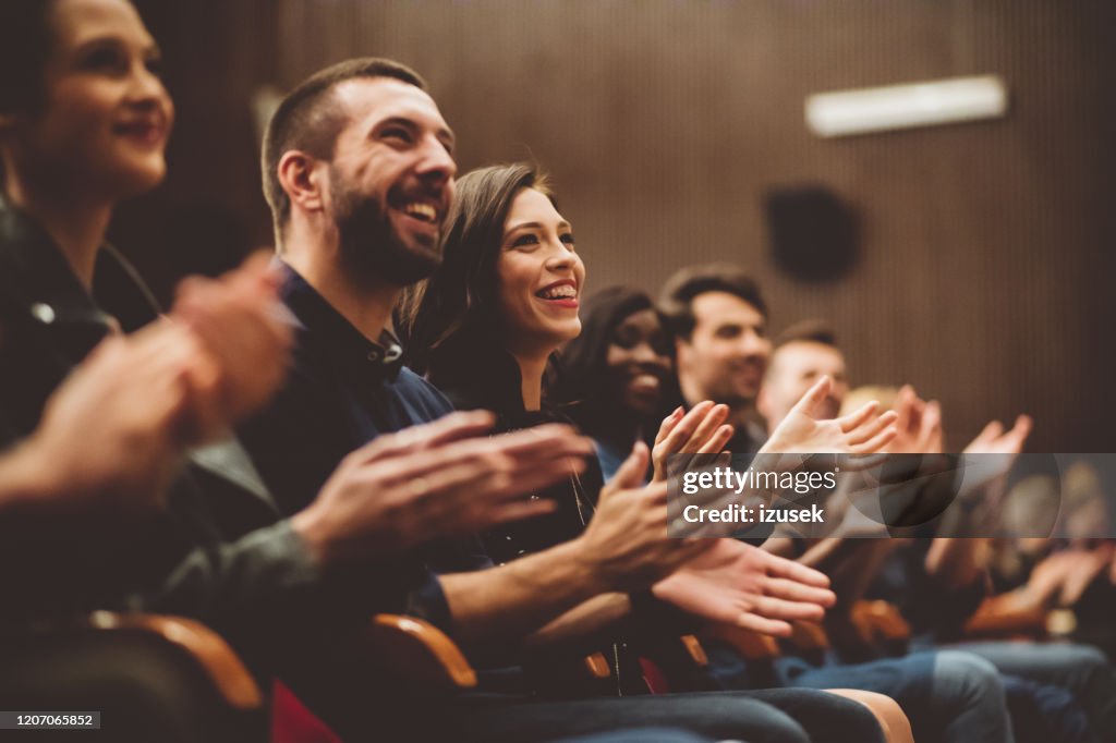 Público feliz aplaudiendo en el teatro