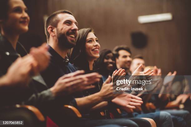 happy audience applauding in the theater - theatre audience stock pictures, royalty-free photos & images