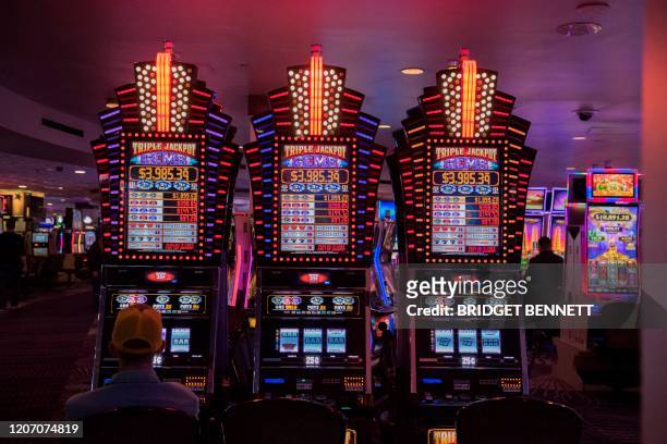 Visitor plays a slot machine at Mirage Hotel and Casino in Las Vegas, Nevada on March 13 as some restaurants, and buffets along The Strip have been...