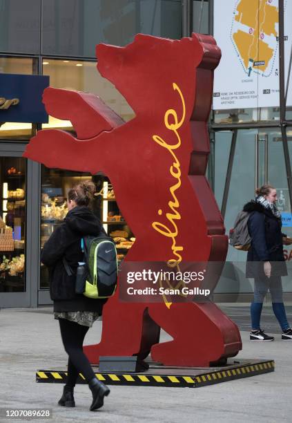 People walk past the Berlinale bear logo outside the Arkaden mall two days before the opening of the 70th Berlinale International Film Festival on...