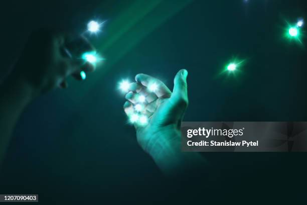 hands collecting lights in darkness - green hands plant stock-fotos und bilder