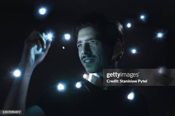 man smiling, holding small light, lights around - new discovery stock pictures, royalty-free photos & images