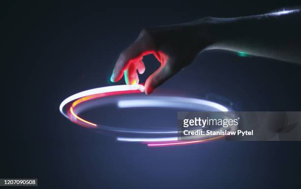 hand controling light circle in air - scoperta foto e immagini stock