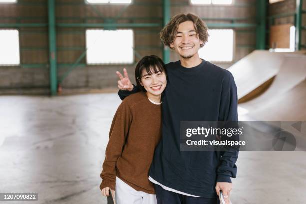 two skateboarders laughing - asian young couple stock pictures, royalty-free photos & images