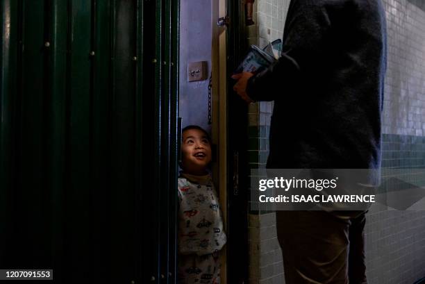 Boy reacts as Hong Kong pro-democracy district councillor Eason Chan distributes face masks and cleaning products at an estate in Lam Tin in Hong...