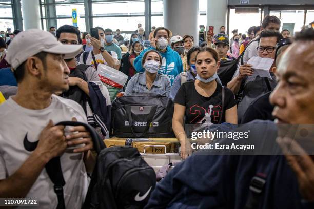 Filipinos hoping to get on flights out of Manila hours before it is placed on lockdown queue at Ninoy Aquino International Airport on March 14, 2020...