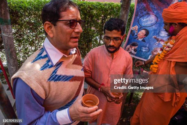 Members and supporters of 'Akhil Bharat Hindu Mahasabha' a Hindu organisation hold earthen pots containing cow urine before drinking it as they...