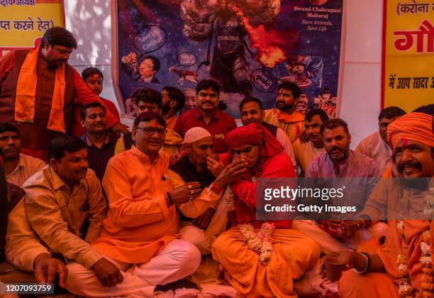 President Chakrapani Maharaj of 'Akhil Bharat Hindu Mahasabha' a Hindu organisation, drinks and offers cow urine to his fellow members, during a...