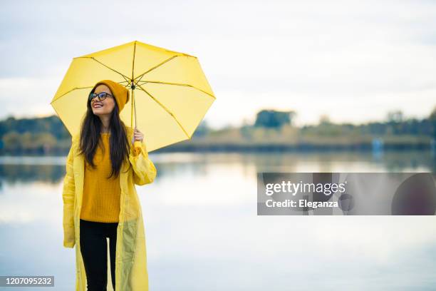 joyful woman walking in rainy weather - rainy season stock pictures, royalty-free photos & images