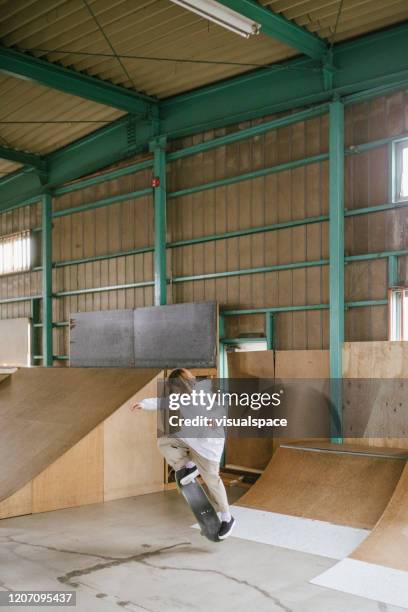 skateboarder making tricks on a rail - indoor skating stock pictures, royalty-free photos & images