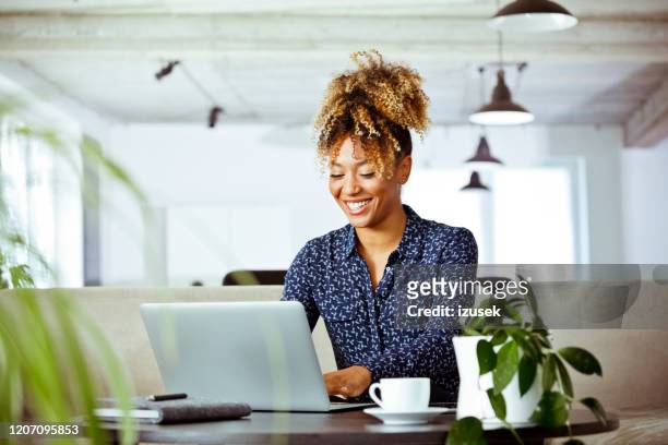 smiling businesswoman using laptop in office - using computer stock pictures, royalty-free photos & images